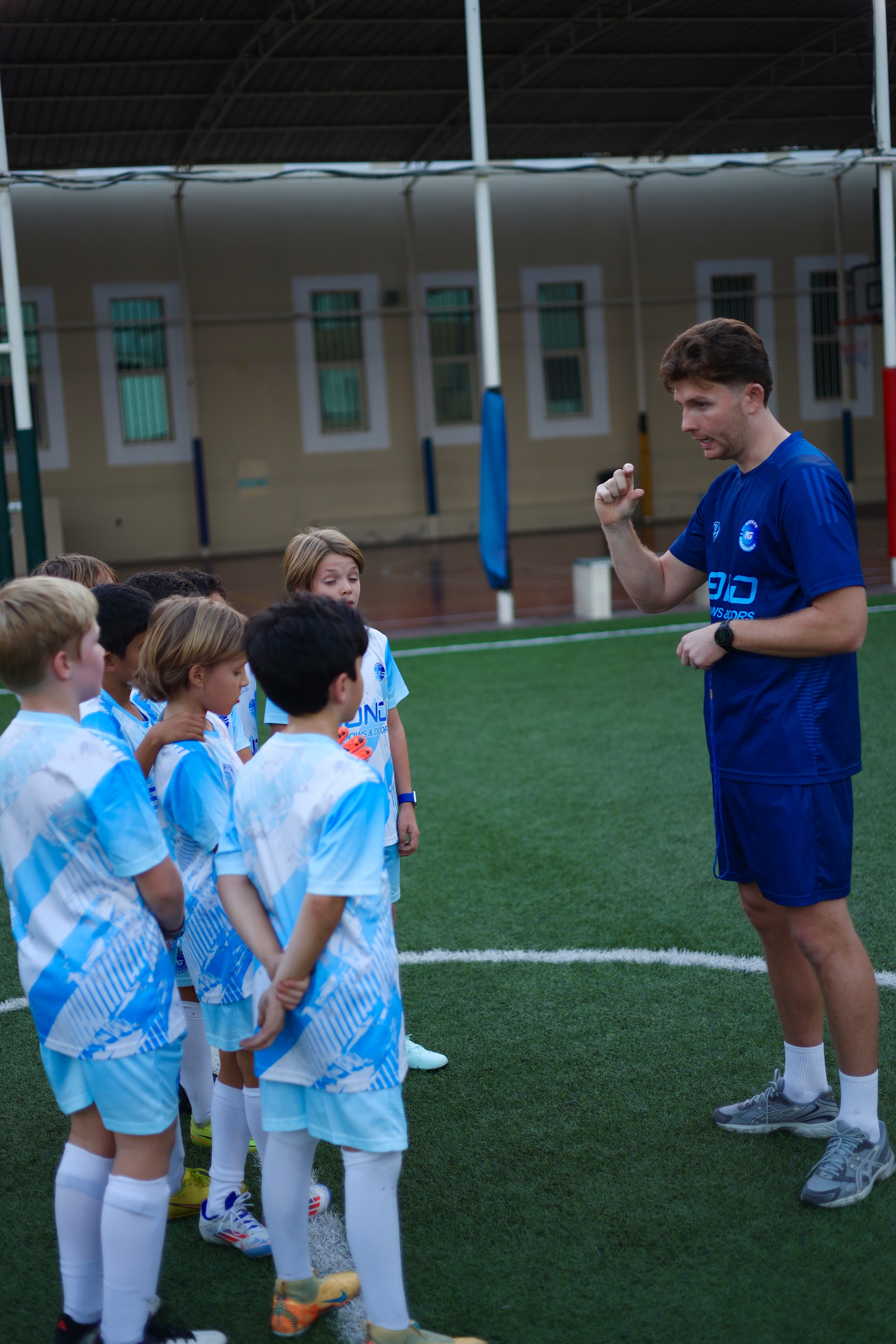 Coach Tommy gives instructions to a group of young NXTGEN players.